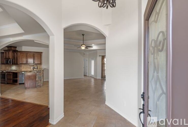 A spacious room with arched doorways and a ceiling fan.