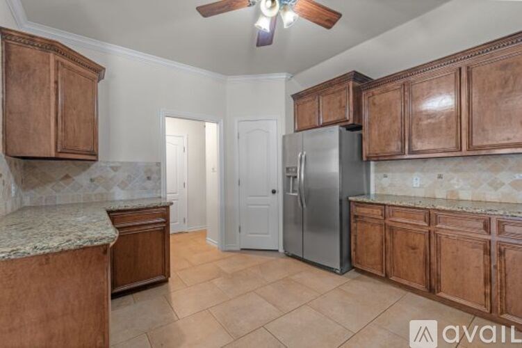 A kitchen with wooden cabinets and a marble countertop.