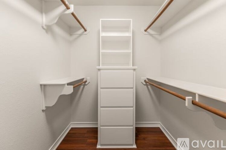 A white ladder stands in a room with white walls and wooden floors.