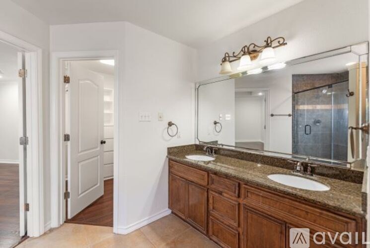 A bathroom with a brown counter top and a large mirror.