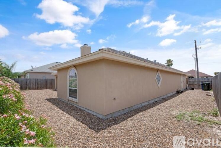 A house with a gravel driveway and a small garden in front.