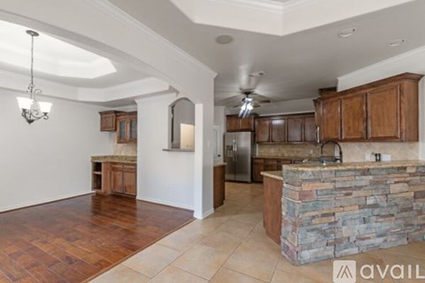 A kitchen with a stone counter and wooden cabinets.