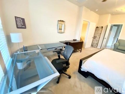 A bedroom with a bed, desk, and chair.