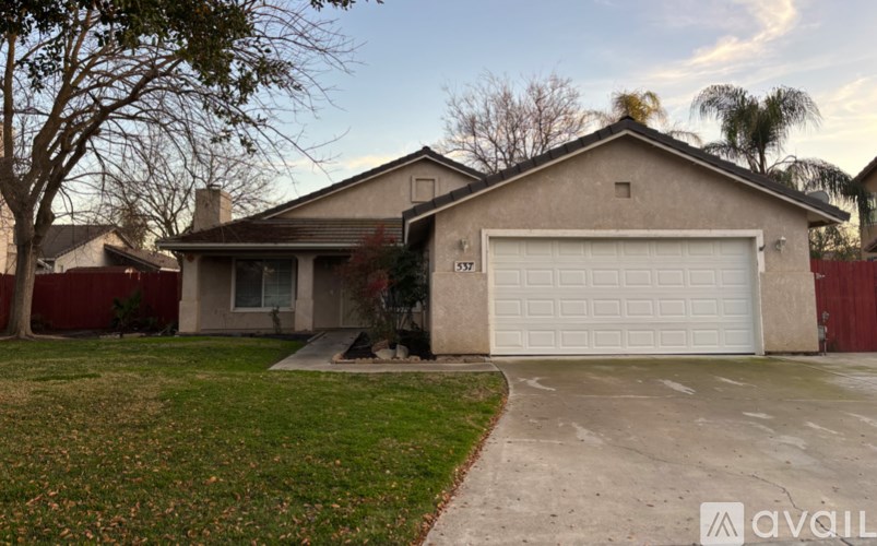 A house with a garage and a driveway in front of it.