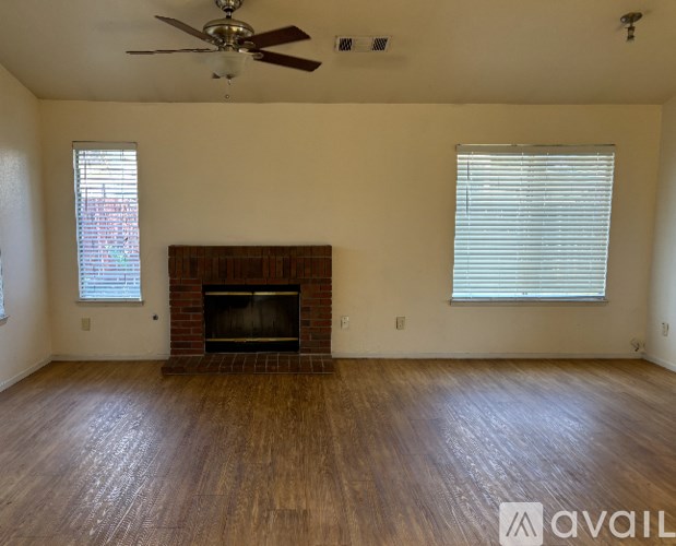 A room with a fireplace and a ceiling fan.