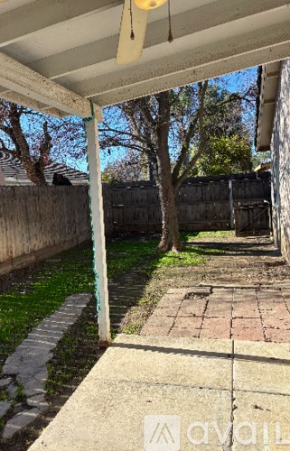 A patio area with a brick walkway and a green pole.