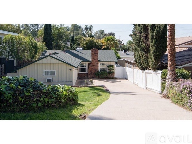 A house with a white fence and a green lawn.