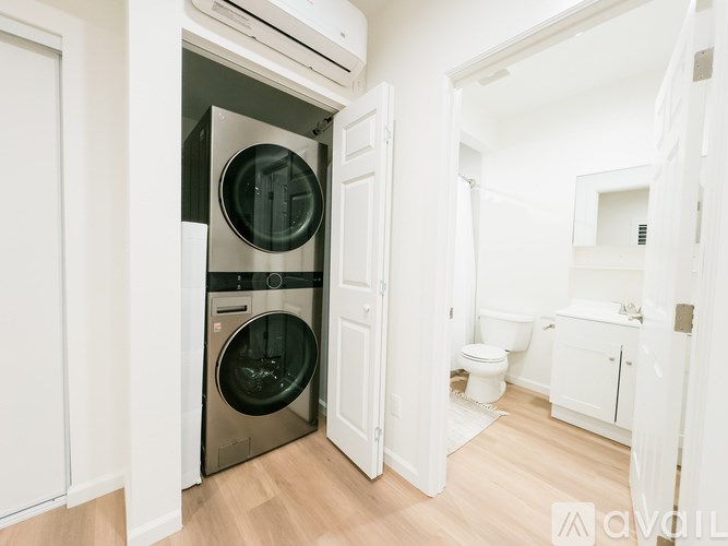 A modern laundry room with a washing machine and dryer built into the cabinetry.