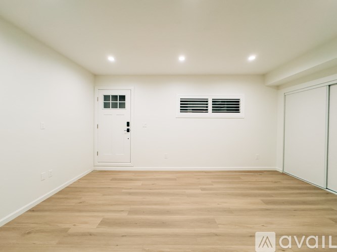 A room with a white door and a window with blinds.