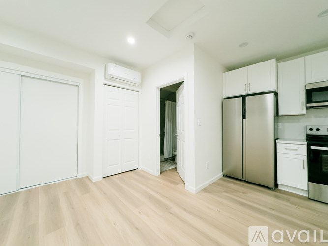 A kitchen with white cabinets and a stainless steel refrigerator.