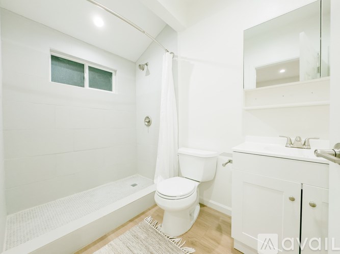 A white bathroom with a toilet, sink, and bathtub.