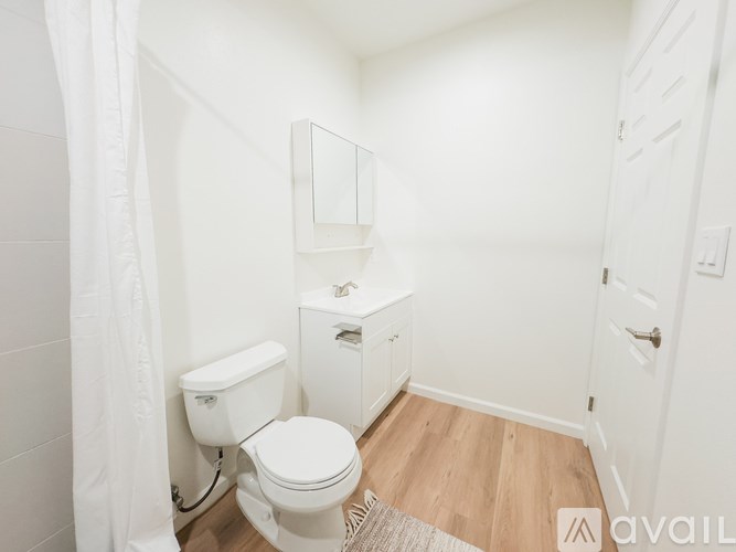 A white bathroom with a toilet, sink, and mirror.