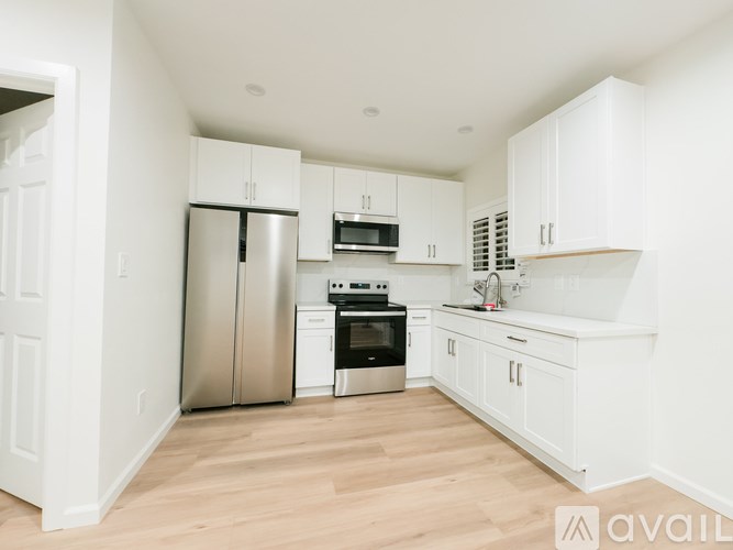 A kitchen with white cabinets and appliances.