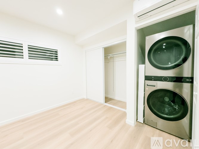 A modern laundry room with a washer and dryer built into the cabinetry.
