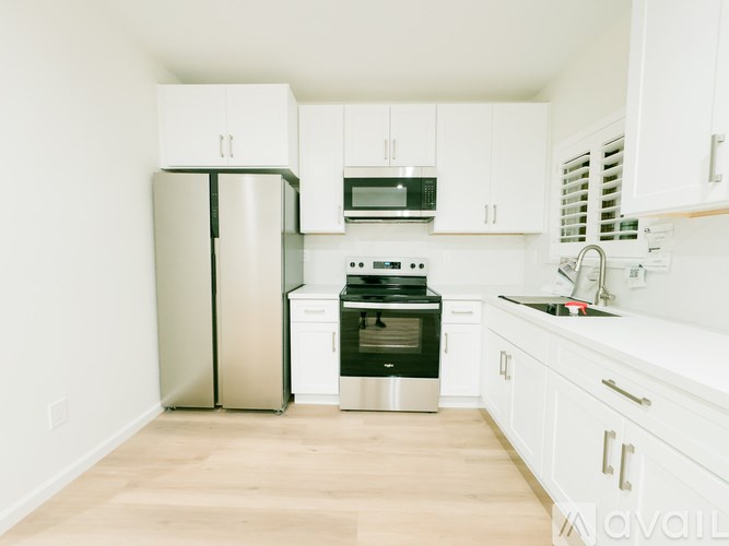 A kitchen with white cabinets and stainless steel appliances.