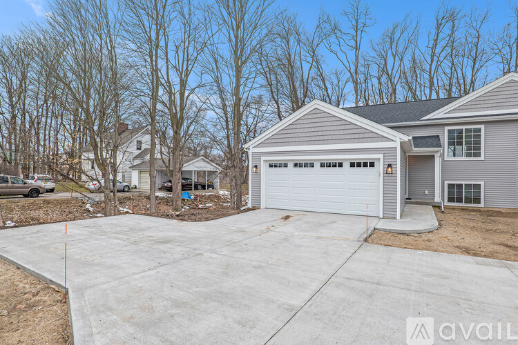 A house with a grey garage door is available for sale.