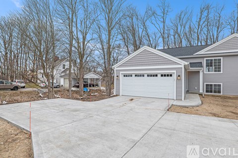 A house with a grey garage door is available for sale.