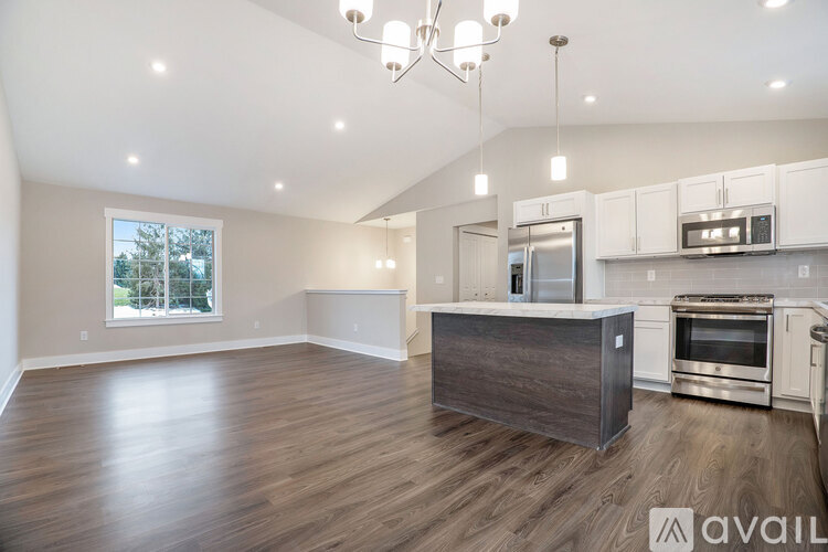 A spacious kitchen with a wooden island and stainless steel appliances.