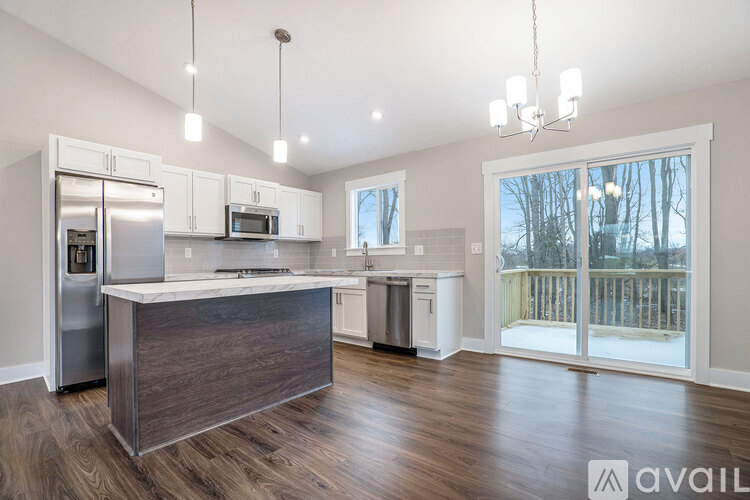 A kitchen with a refrigerator, microwave, and a countertop with a sink.