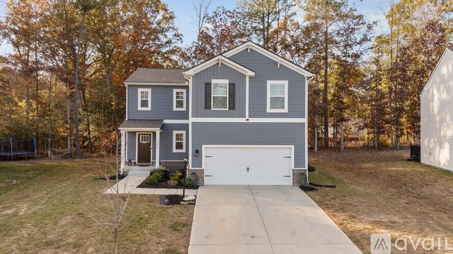 A two-story house with a garage is available for sale.