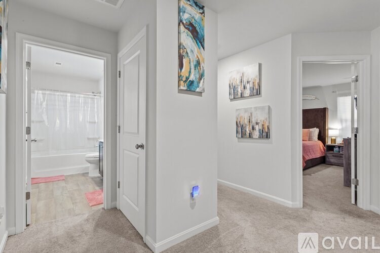 A bedroom with a bed, a painting, and a mirror.