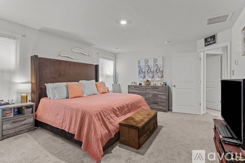 A bedroom with a large bed and a wooden headboard.