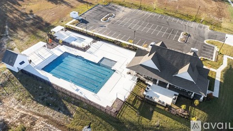 A large house with a pool and a parking lot.