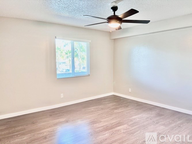 A room with a ceiling fan and a window.