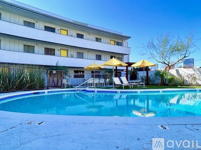 A large white building with a pool in front of it.