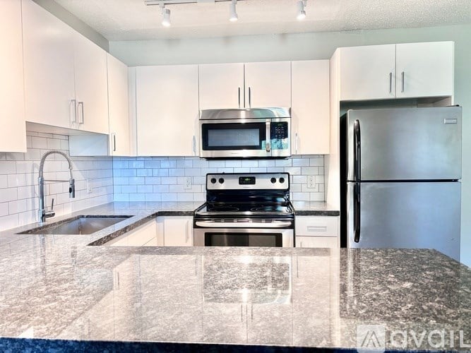 A kitchen with a granite countertop and stainless steel appliances.
