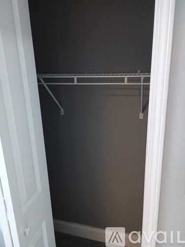 A white door with a white frame and a white coat rack with five hooks.