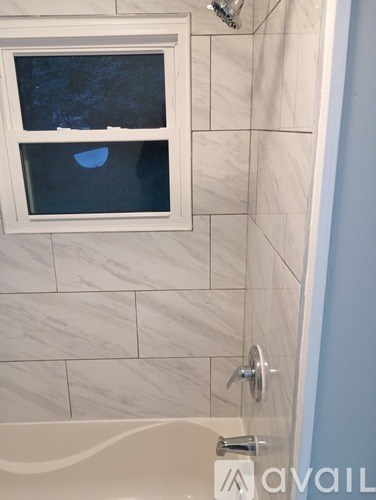A bathroom with a tub and a window.