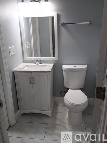 A bathroom with a toilet, sink, and medicine cabinet.
