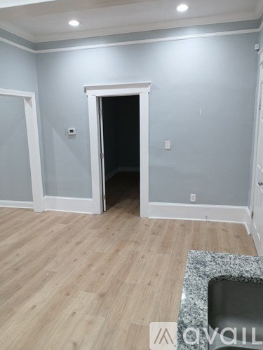 A room with a wooden floor and a marble countertop.