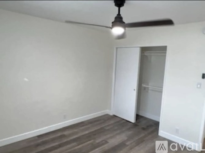 A room with a ceiling fan and a doorway leading to another room.