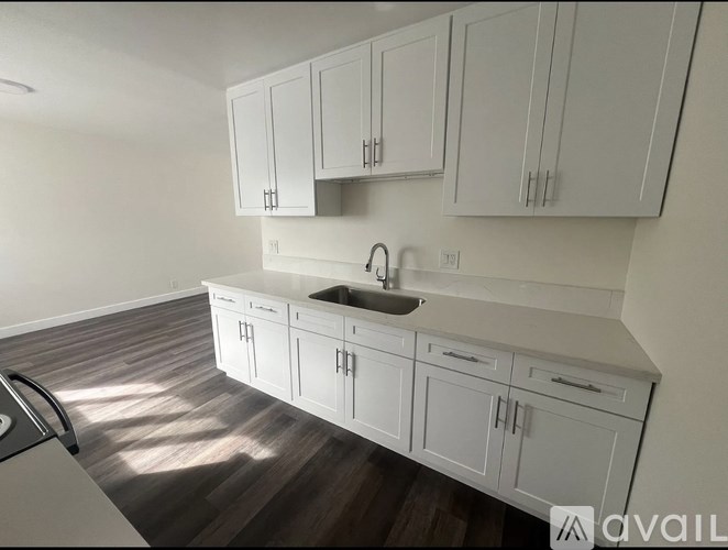 A kitchen with white cabinets and a sink.