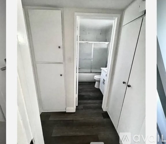 A white kitchen with a white fridge and a white door.