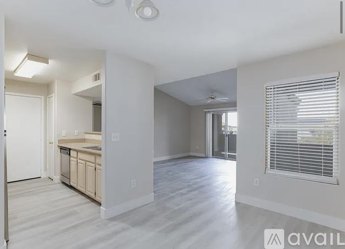 A spacious living room with a kitchen in the background.