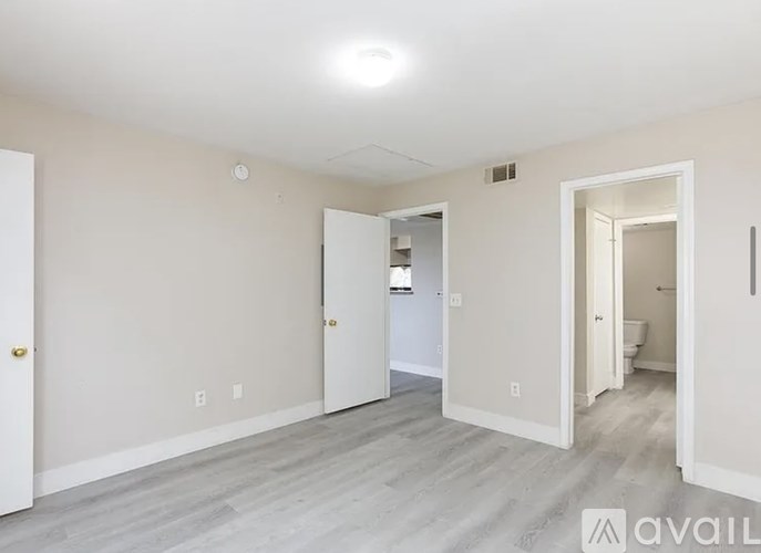 A spacious room with a doorway leading to another room.