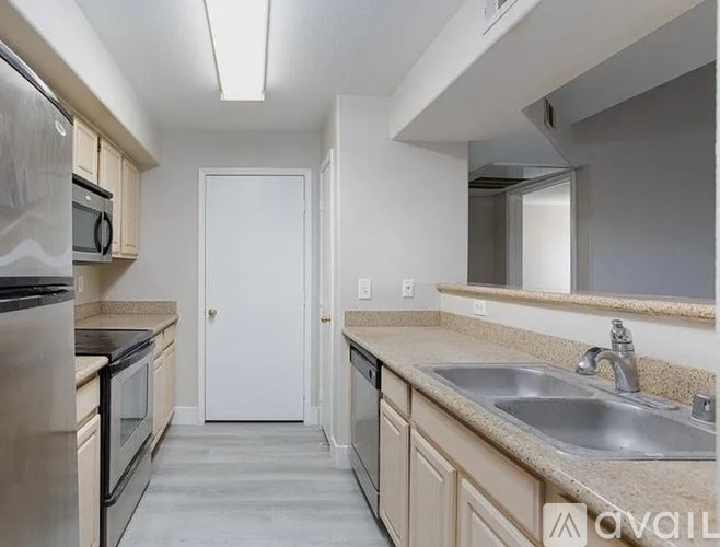 A kitchen with a sink, stove, and oven.