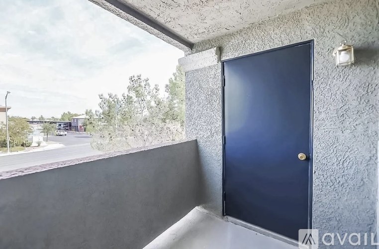 A blue door is on the right side of a concrete wall.
