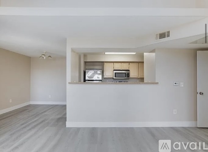 A spacious living room with a window seat and a microwave.