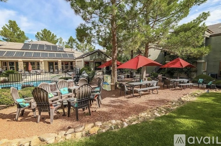 A patio area with tables and chairs and umbrellas.