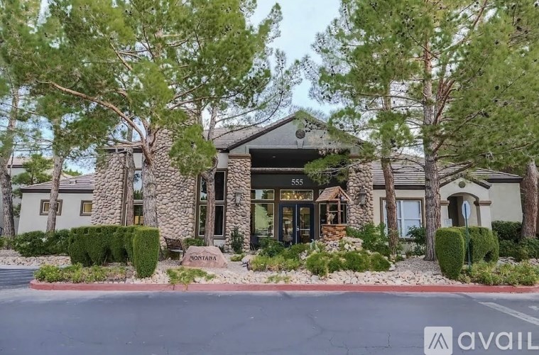 A building with the number 555 on it is surrounded by trees and bushes.