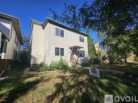 A house is for rent and is surrounded by greenery.
