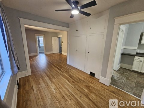 A room with wooden flooring and a ceiling fan.