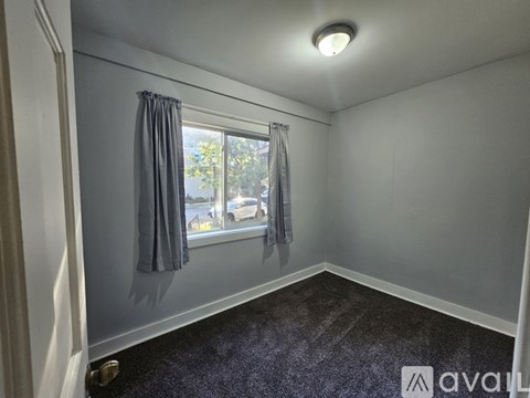 A room with a window and curtains.