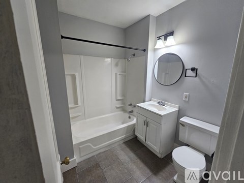 A bathroom with a toilet, sink, and bathtub.