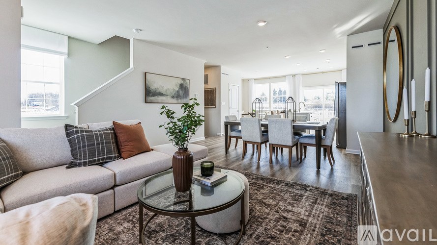 A living room with a couch, a coffee table, and a painting on the wall.