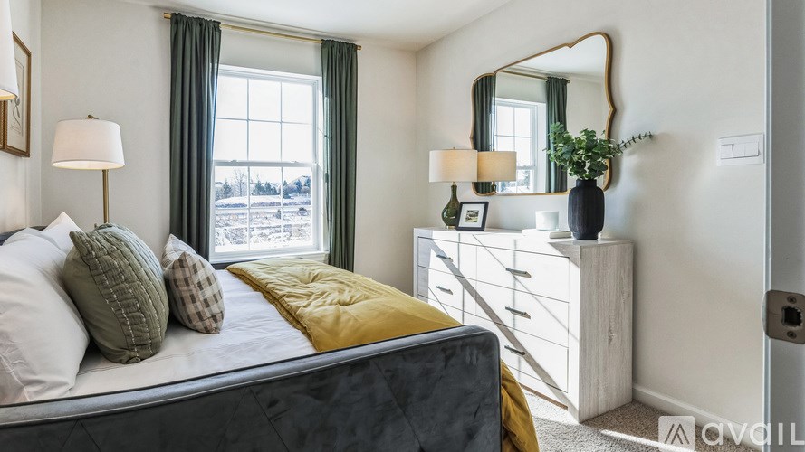 A bedroom with a bed, dresser, and mirror.